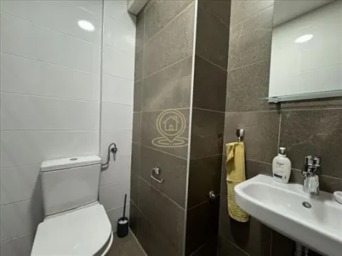 Smaller bathroom equipped with a toilet, washbasin, and mirror. - image 7
