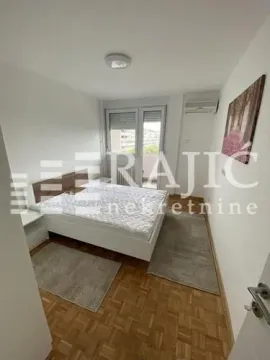 Spavaća soba sa bračnim krevetom, parketom i izlazom na terasu. - image 9