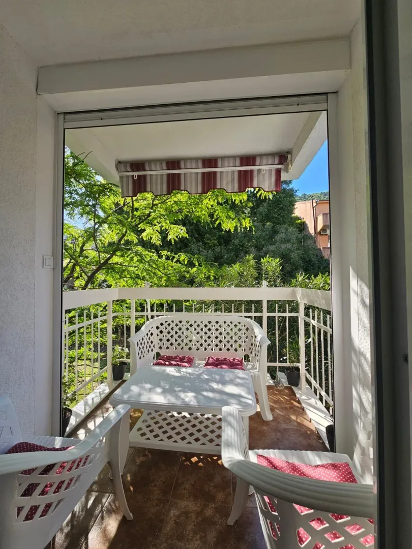 Namještena terasa sa garniturom za sjedenje i pogledom na zelenilo.