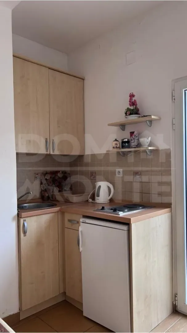 Manja drvena kuhinja sa sudoperom, mini frižiderom i rešoom.