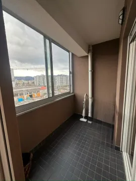 Zastakljeni balkon sa pločicama na podu i pogledom na grad. - image 8