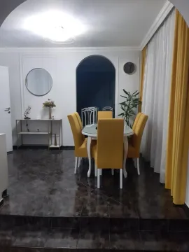 Dining area with a table and yellow chairs within the living room. - image 7