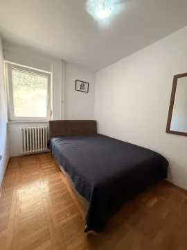 Small bedroom with a double bed and parquet flooring. - image 6