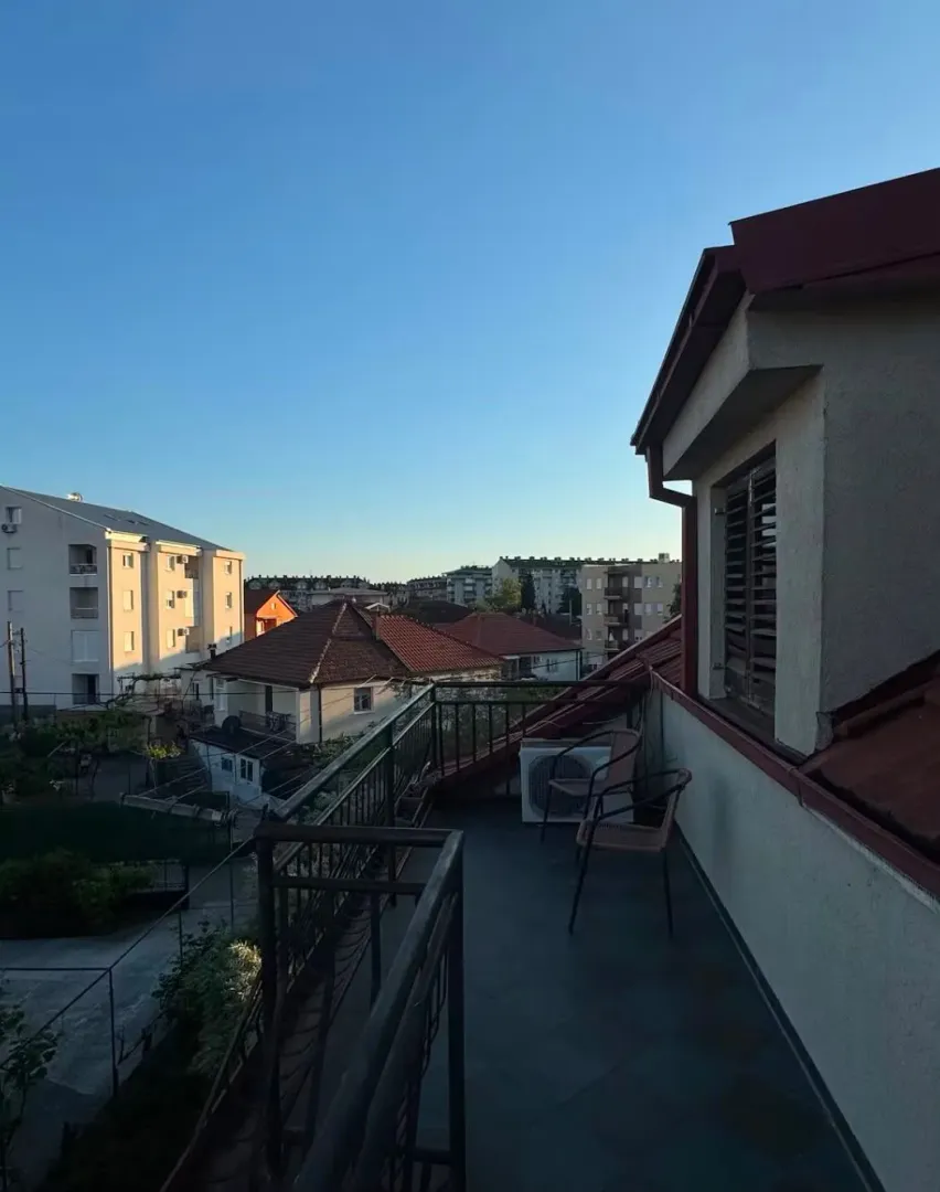 Prostrana terasa sa garniturom za sjedenje i pogledom na grad.