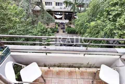 Small balcony with seating furniture and a view of greenery and the street. - image 13