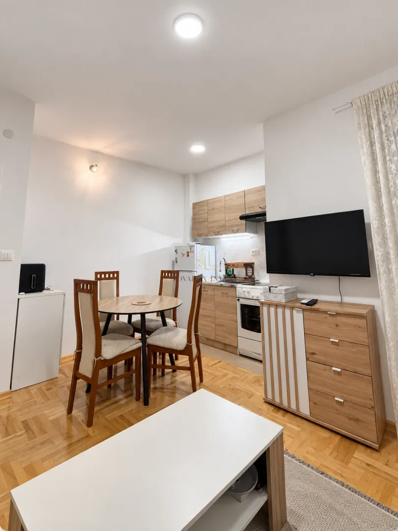 Living room with dining area and a fitted kitchen in the background.