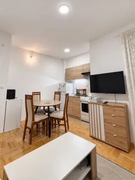 Living room with dining area and a fitted kitchen in the background. - image 2