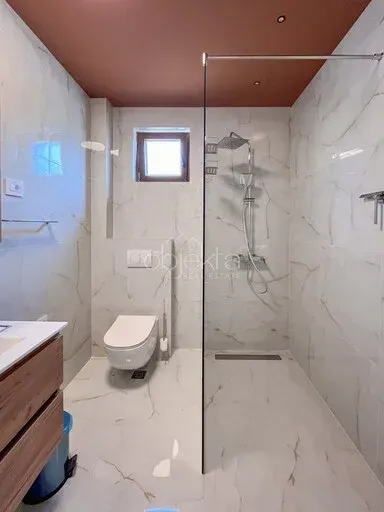 Moderne kupatilo sa tuš kabinom, WC šoljom i umivaonikom.