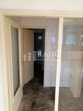 Tiled bathroom with a door and a glass partition. - image 9
