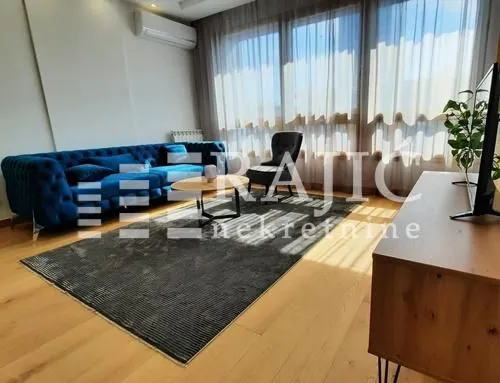 Modern and bright living room with a blue sofa and large windows.