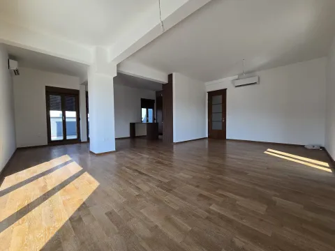Spacious empty living room with parquet flooring and white walls. - image 9