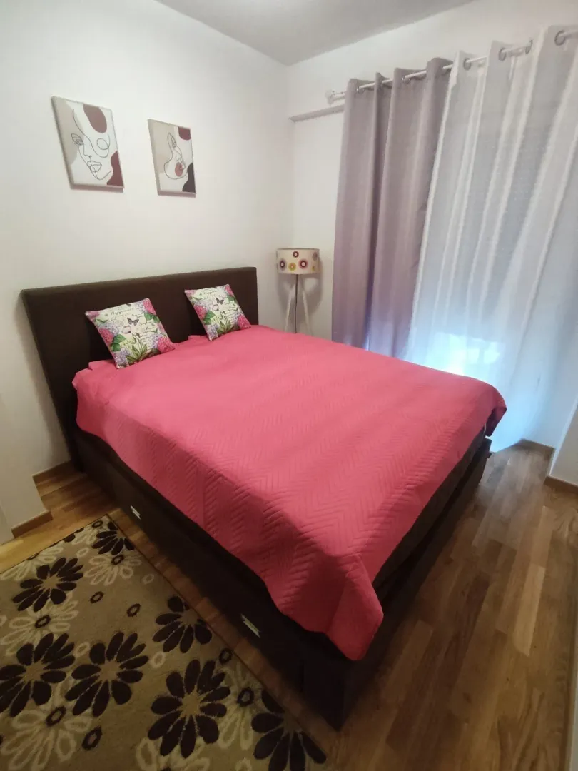 Bright bedroom featuring a double bed with a pink bedspread.