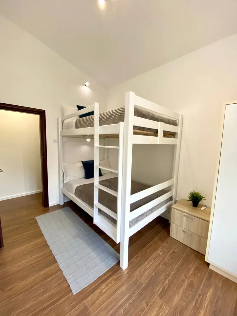 Bedroom with a bunk bed and wooden flooring.