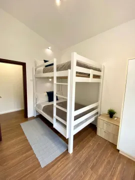 Bedroom with a bunk bed and wooden flooring. - image 11