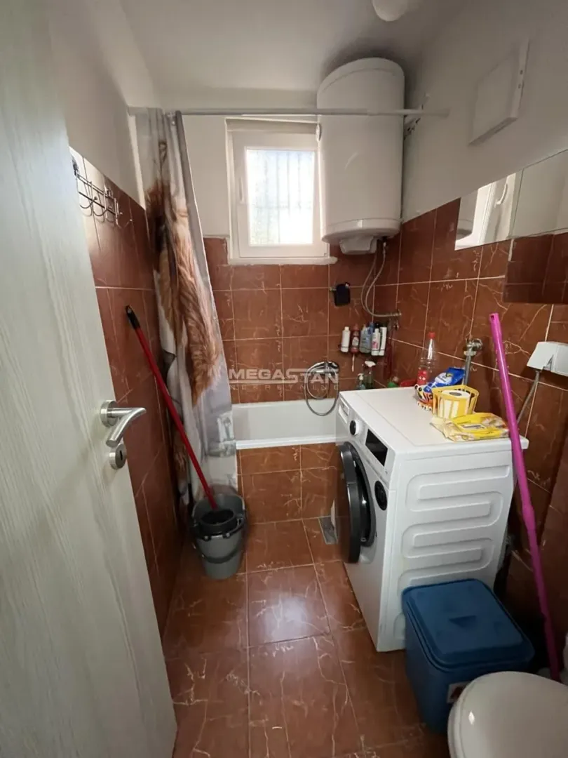Manje kupatilo sa kadom, veš mašinom i bojlerom.