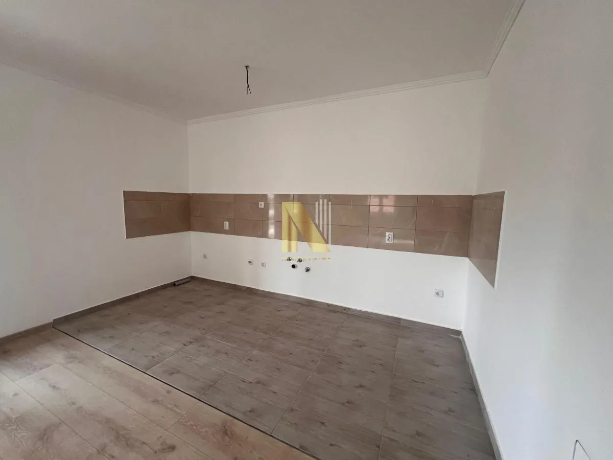 Prazan prostor kuhinje sa zidnim pločicama i instalacijama.