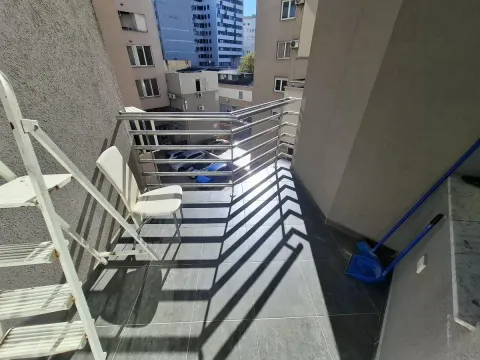 Manji popločani balkon sa metalnom ogradom i pogledom na okolne zgrade. - image 5