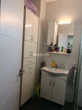 Smaller bathroom with a washbasin, mirror and white storage cabinet. - image 8
