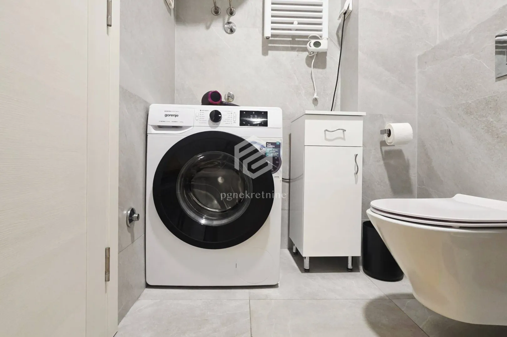 Bathroom equipped with sanitary ware and a washing machine.