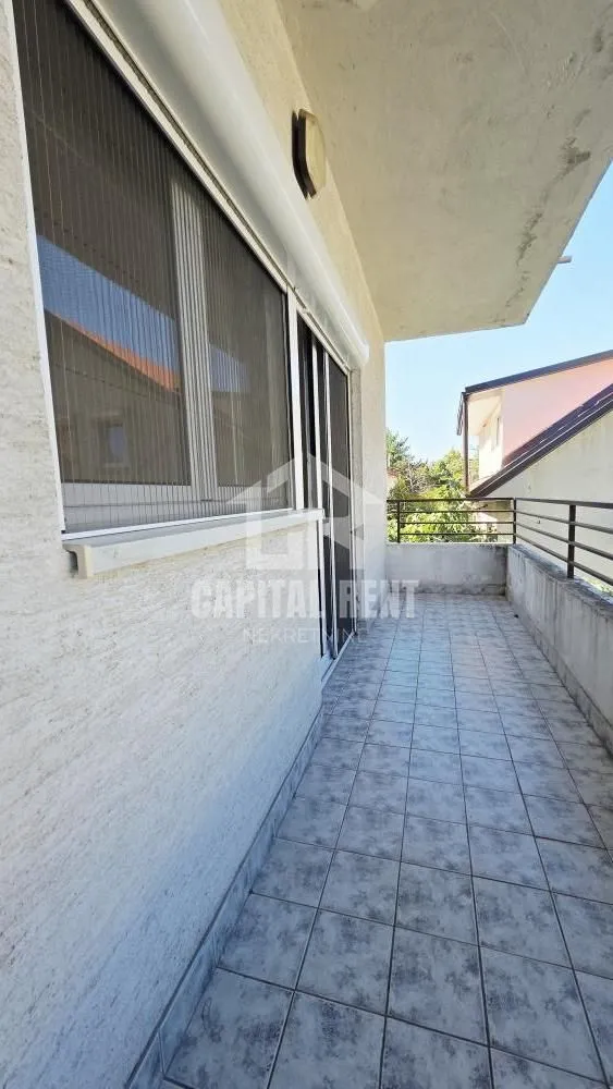 Spacious tiled balcony with a railing and a view of the surroundings.
