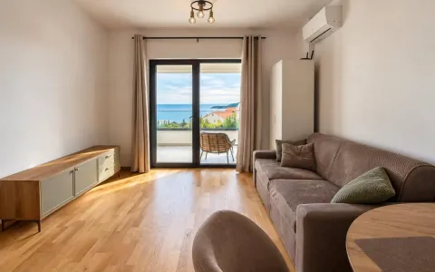 Living room with a sofa, TV unit, and access to a terrace with a sea view. - image 4