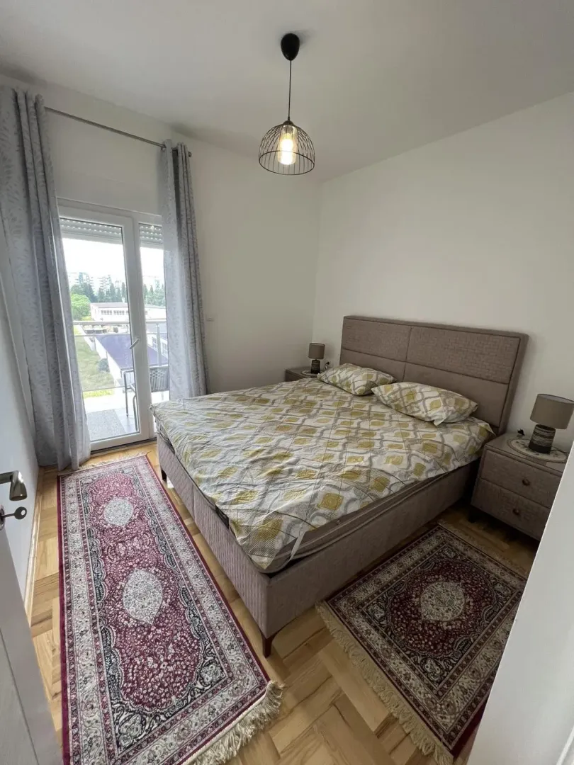 Bright bedroom with a double bed and balcony access.
