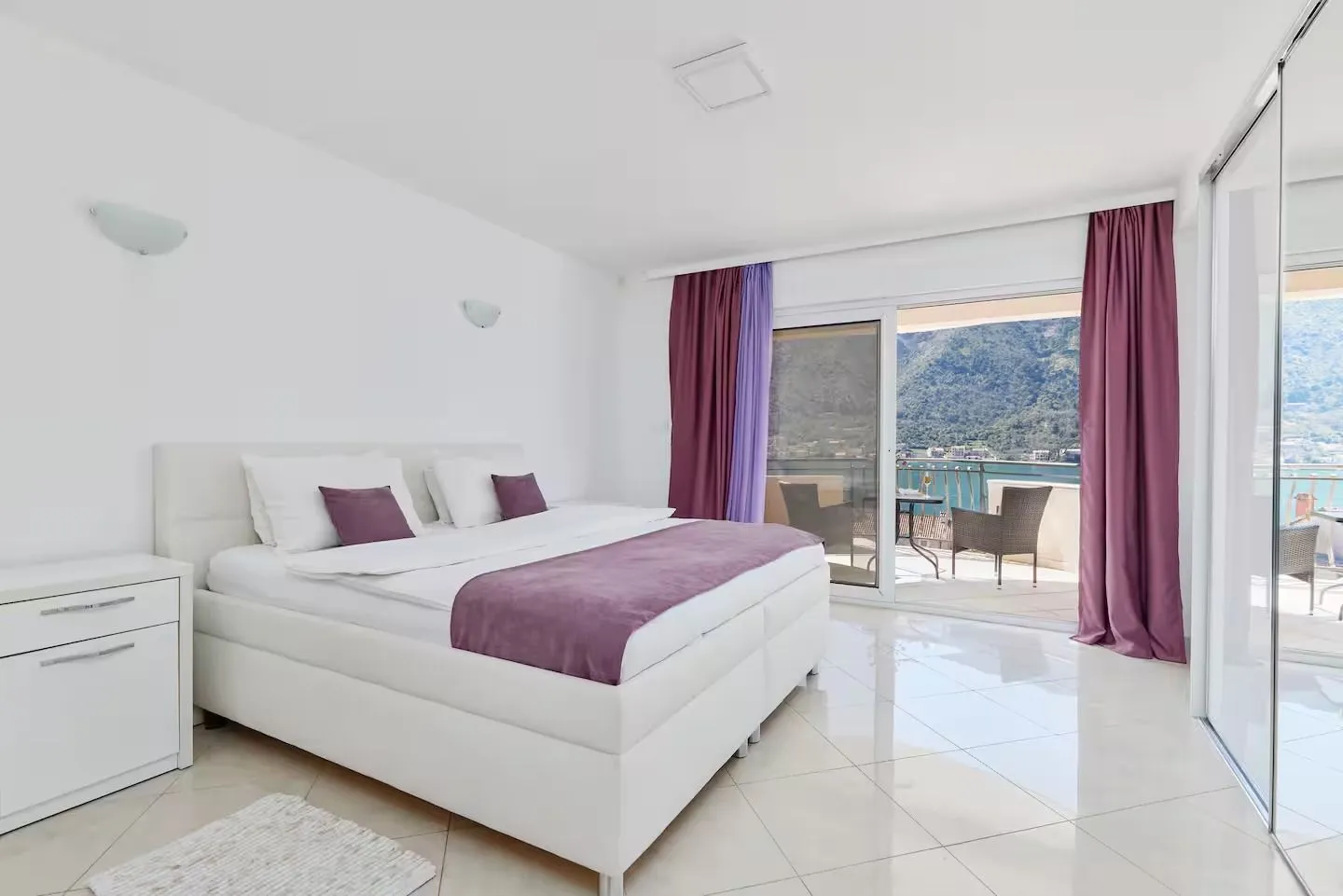 Bright bedroom with a double bed and access to a terrace with a sea view.