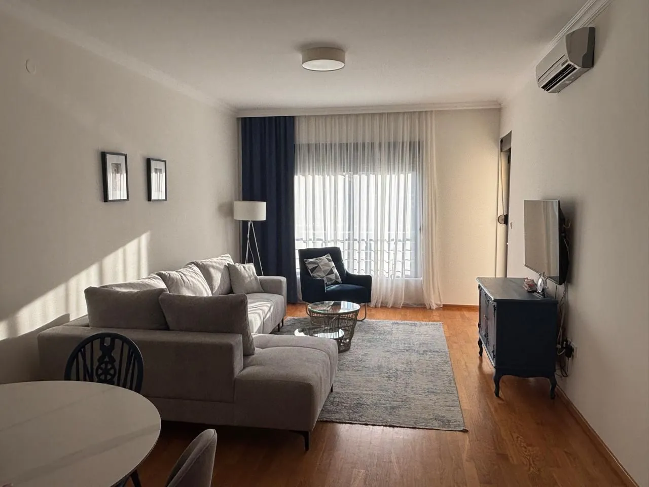 Living room with sofa, TV and dining table.