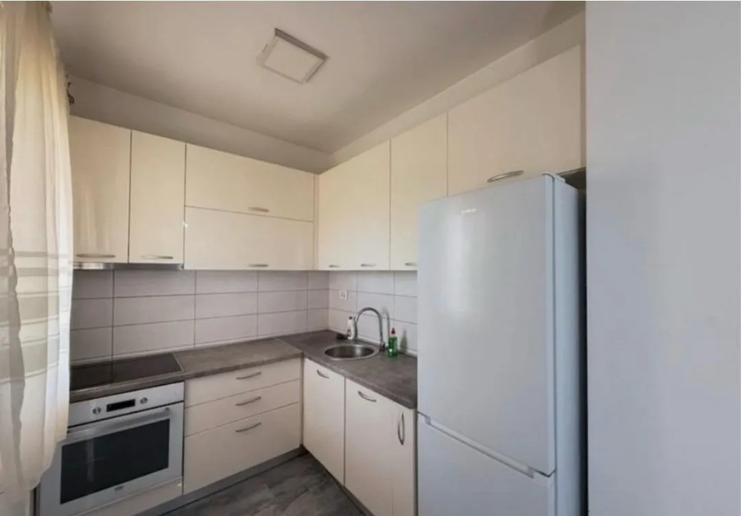 Small kitchen with white cabinetry and white appliances.
