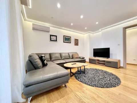 Bright living room with a grey corner sofa and a TV. - image 7