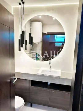 Modern bathroom with a sink, mirror, and pendant lights. - image 9