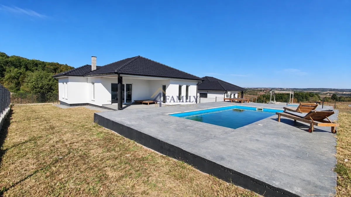 Exterior of a modern house with a swimming pool and grassy yard.