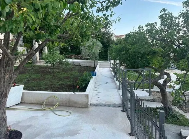 A landscaped yard with a pathway and greenery.