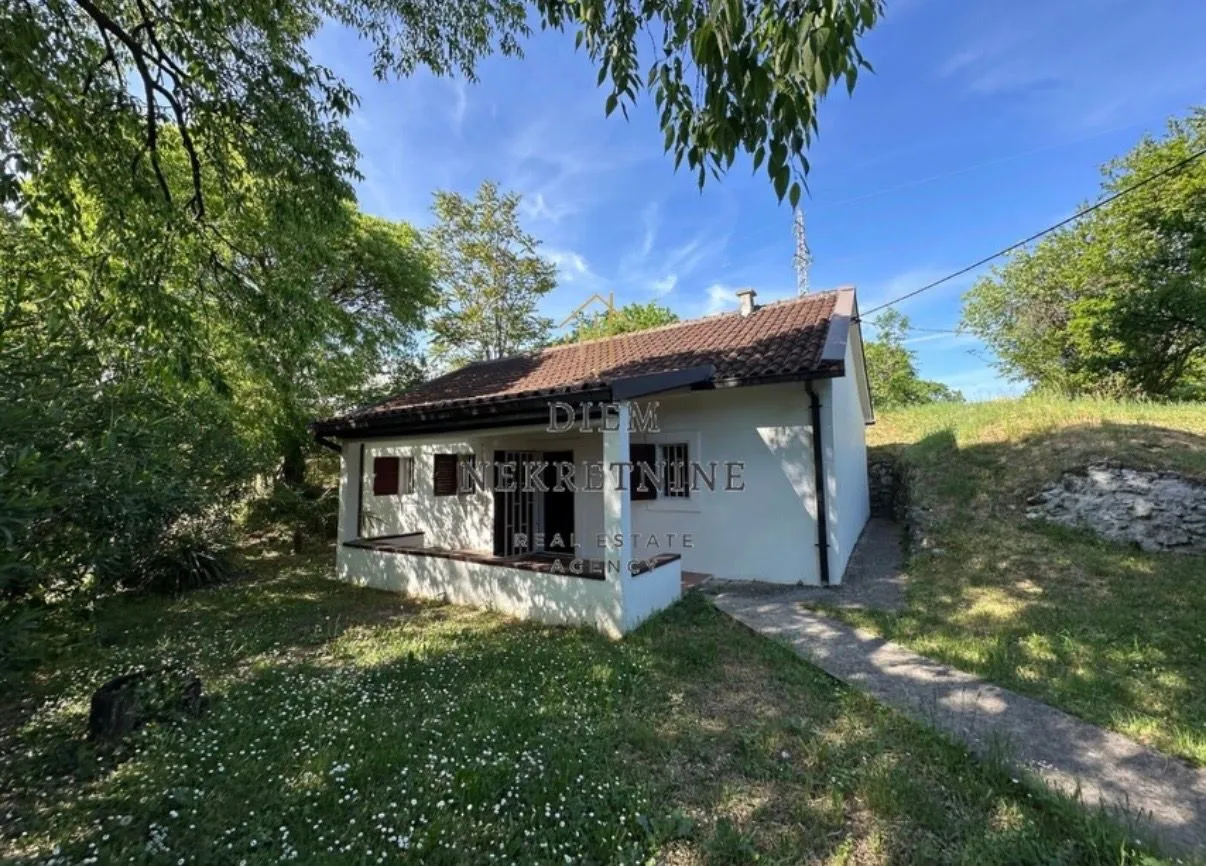 Exterior of a ground-floor house with a yard and a covered terrace.