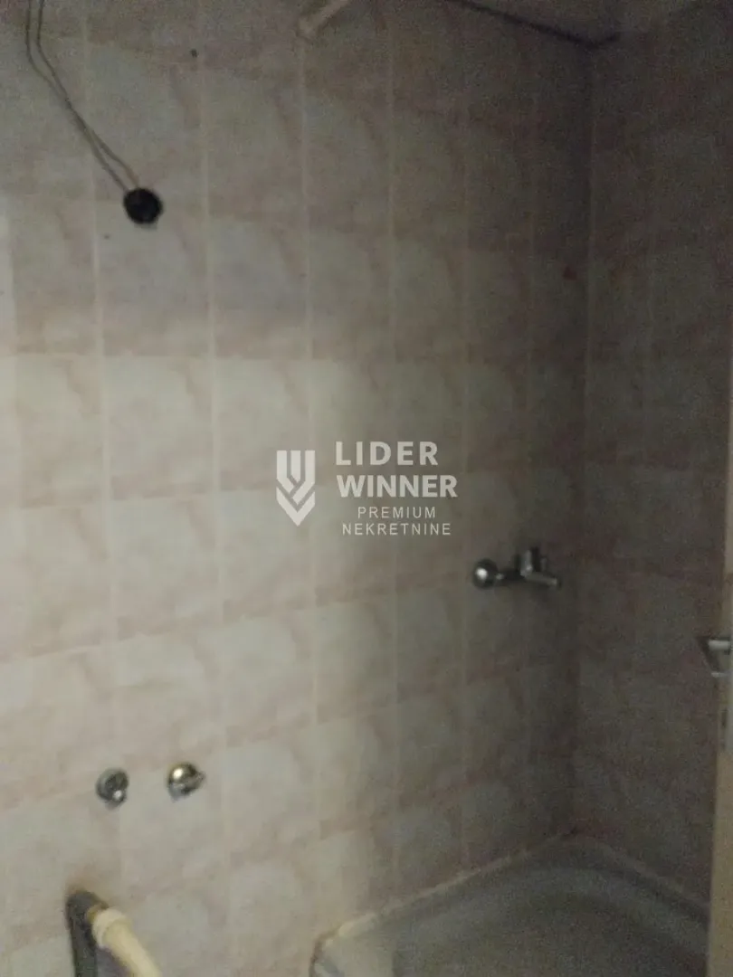 View of the bathroom with ceramic tiles and a shower cabin.