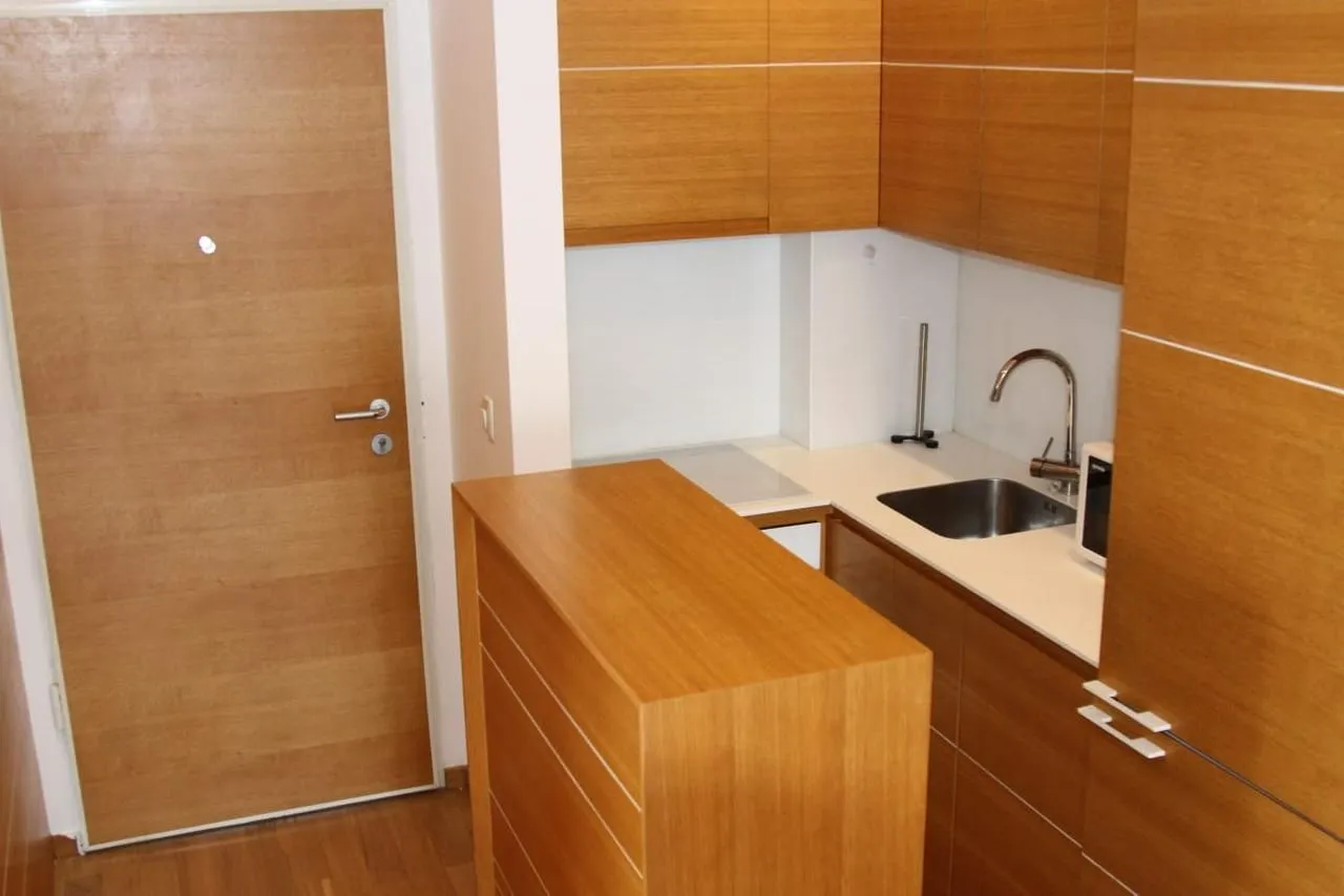 Small modern kitchen with wooden cabinets and a sink.