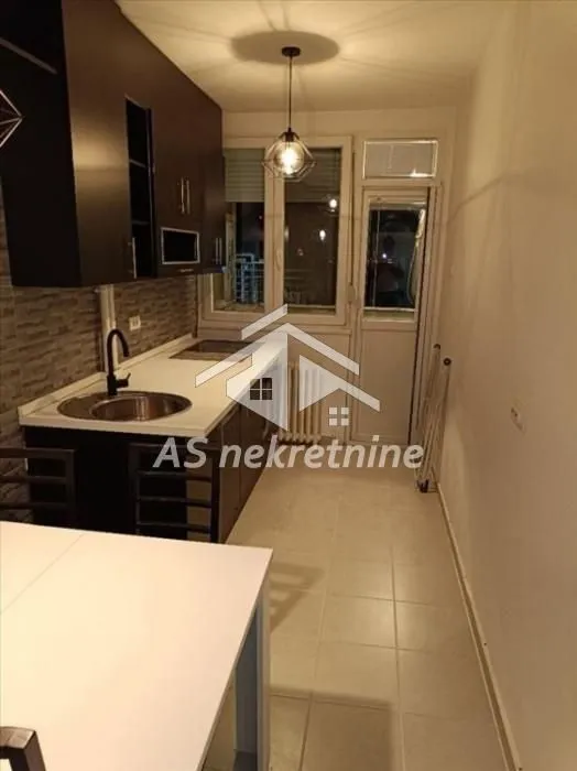 Small equipped kitchen with a dining table and access to the terrace.