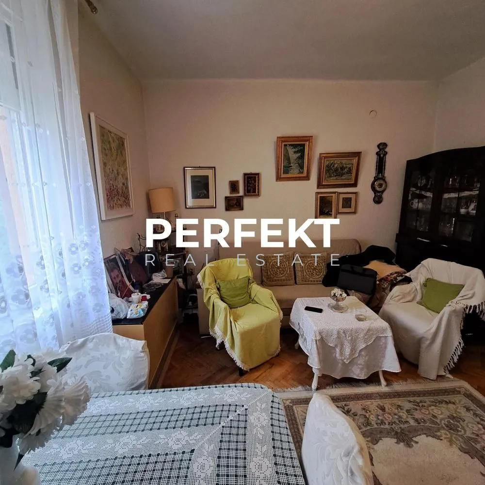 Dnevna soba sa garniturom za sedenje, stočićem i nameštajem.