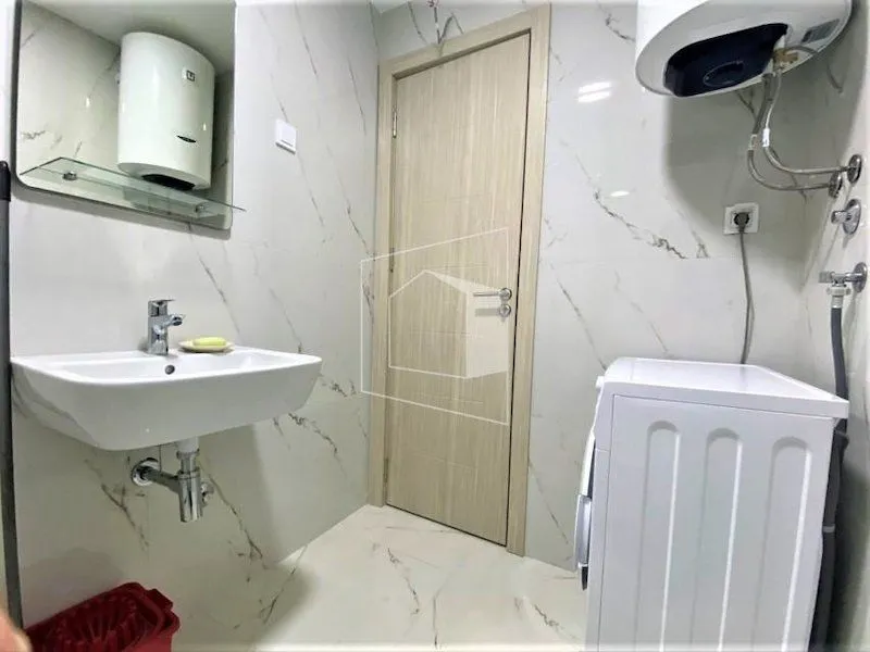 Moderne kupatilo sa umivaonikom, veš mašinom i bojlerom.