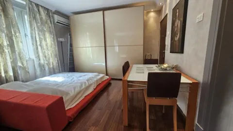 Spavaća soba sa krevetom, velikim plakarom i trpezarijskim stolom sa stolicama. - image 8