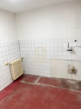 Prazna prostorija sa pločicama na zidu, radijatorom i priključcima za vodu. - image 6