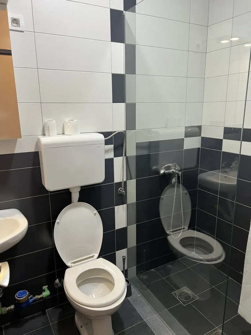 Modern bathroom with black and white tiles and a shower cabin.