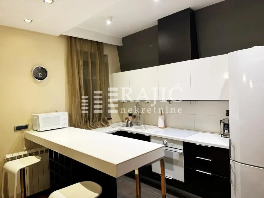 Modern kitchen with a breakfast bar and white cabinetry.