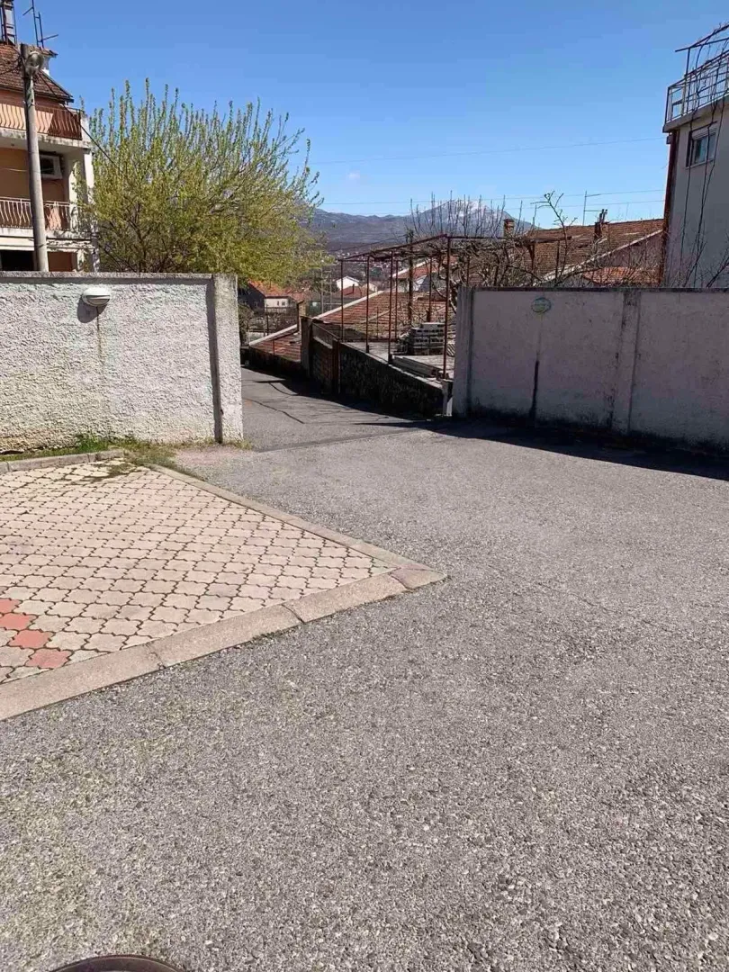Dvorište i prilazni put ispred objekta sa pogledom na planine.