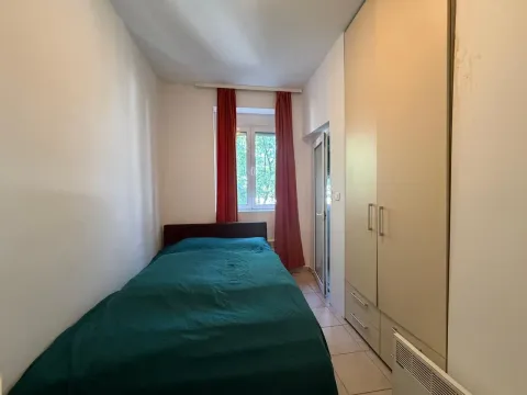 Manja spavaća soba sa krevetom, garderoberom i crvenim zavjesama. - image 6