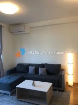 Living room with a sectional sofa, coffee table, and air conditioning unit. - image 2