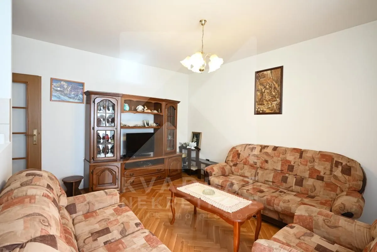 Living room with a sofa set, wooden furniture and parquet flooring.