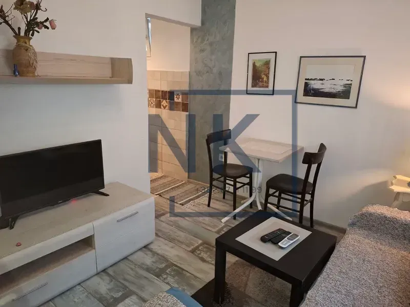 Living room with a TV, sofa set, and a small dining table.
