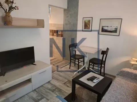 Living room with a TV, sofa set, and a small dining table. - image 2