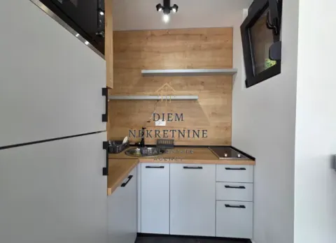 Small modern kitchen with white cabinets and a wooden wall panel. - image 9